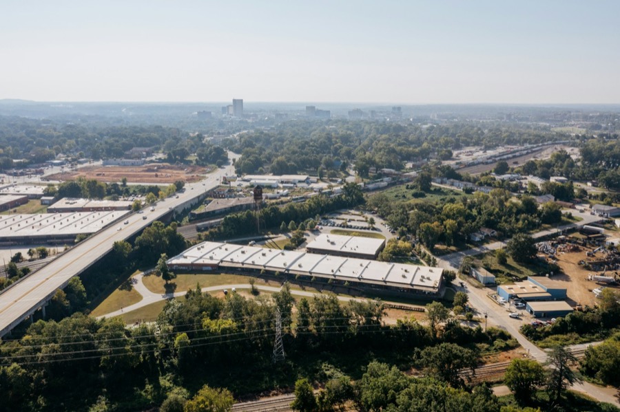Industrial buildings beside a highway overpass, seen from above